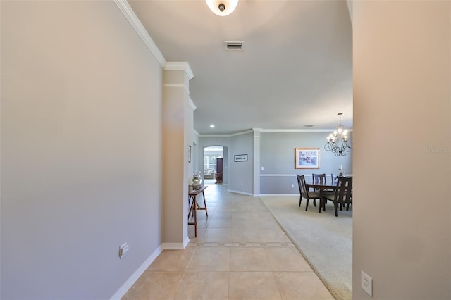 hall featuring light tile patterned floors, a chandelier, and ornamental molding