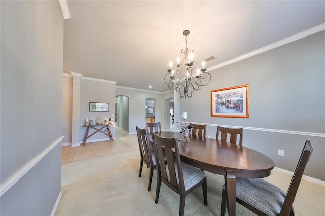 dining area featuring decorative columns, light colored carpet, a chandelier, and ornamental molding