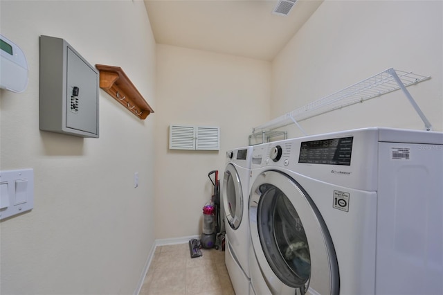 washroom with independent washer and dryer and light tile patterned floors