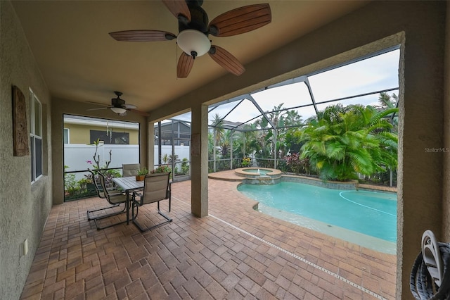 view of pool with ceiling fan, a patio area, an in ground hot tub, and glass enclosure