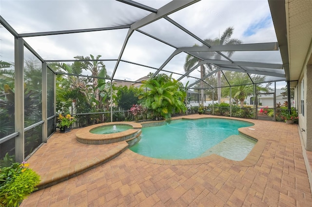 view of pool featuring glass enclosure, a patio area, and an in ground hot tub