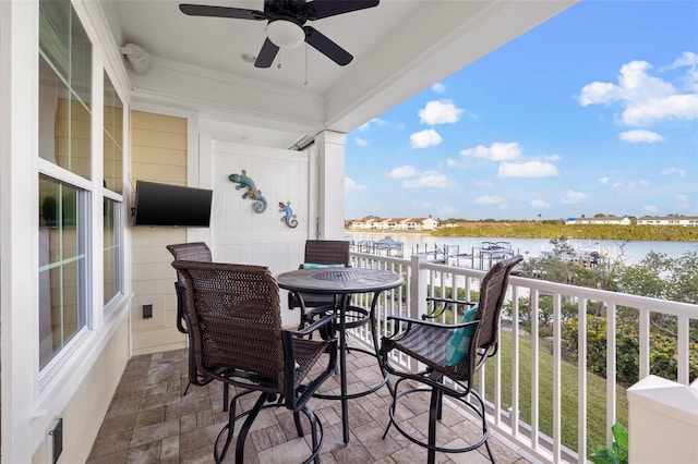 balcony featuring ceiling fan and a water view