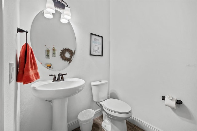 bathroom with hardwood / wood-style flooring, toilet, and sink