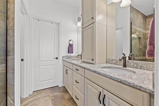 bathroom featuring a shower with door and vanity