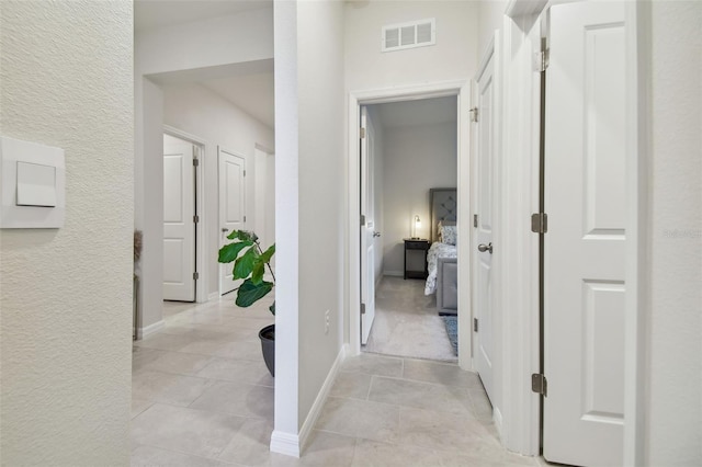 hall featuring light tile patterned flooring