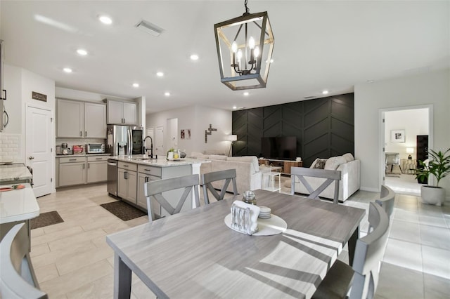 dining space with sink and a notable chandelier