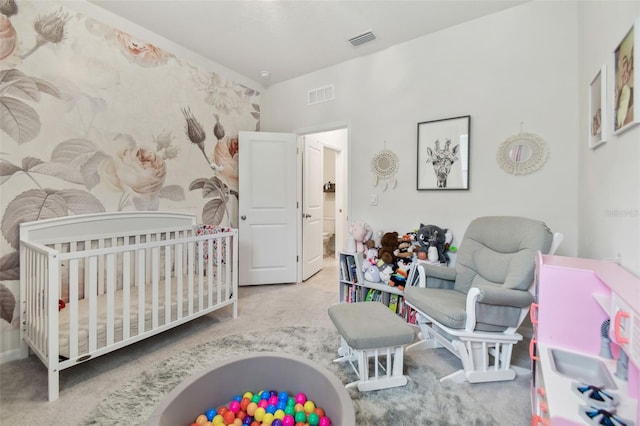 bedroom featuring a crib and light carpet