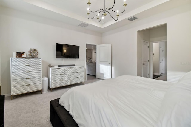 bedroom featuring carpet, an inviting chandelier, a tray ceiling, and ensuite bath