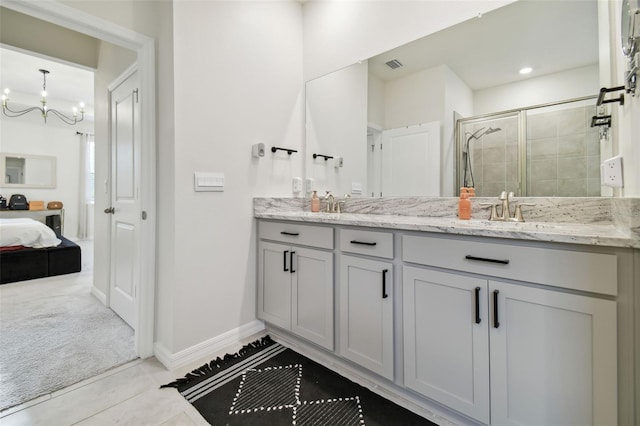 bathroom featuring tile patterned flooring, vanity, a notable chandelier, and walk in shower