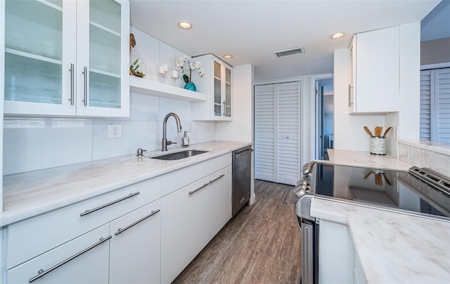 kitchen featuring light stone countertops, sink, dark wood-type flooring, white cabinets, and appliances with stainless steel finishes