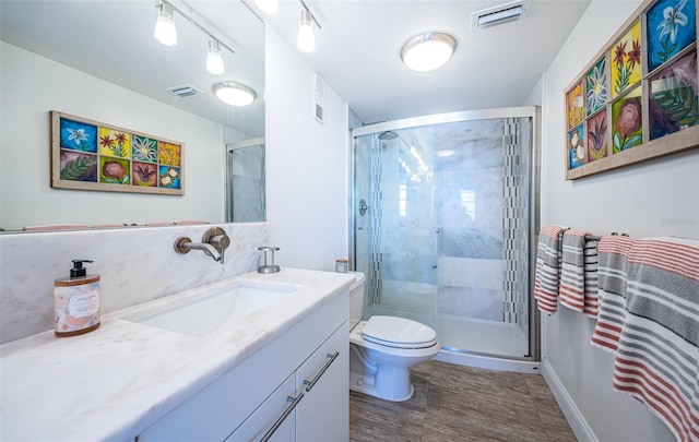 bathroom featuring vanity, toilet, and walk in shower