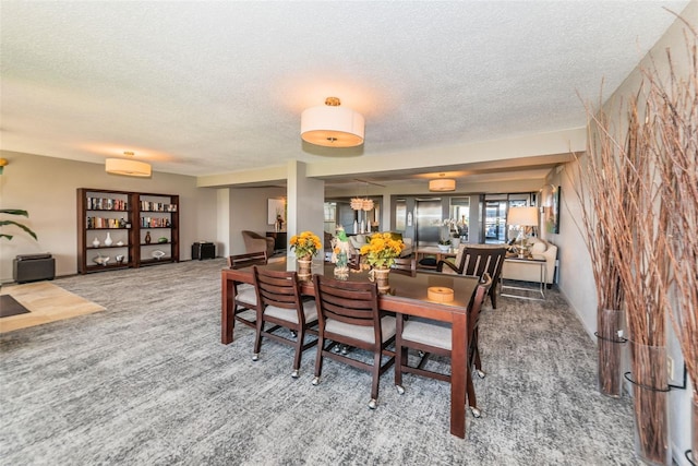 dining area with carpet flooring, a wall unit AC, and a textured ceiling