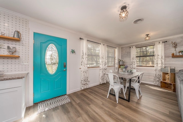 dining area featuring hardwood / wood-style flooring and crown molding