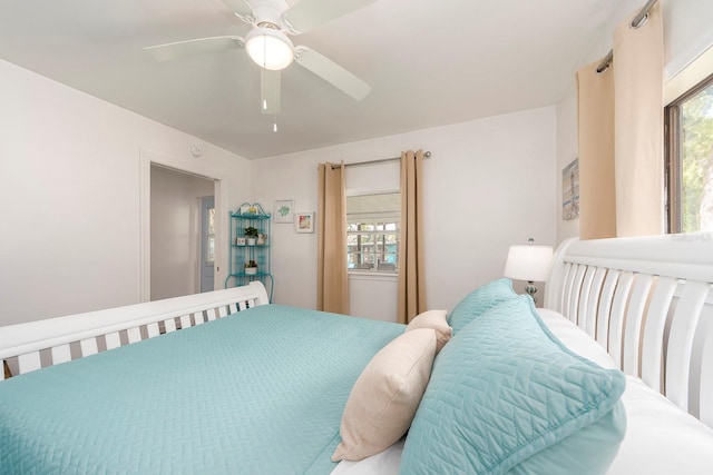 bedroom with ceiling fan and multiple windows