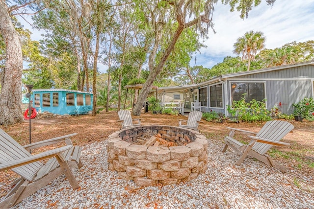 view of patio / terrace with a fire pit and a sunroom