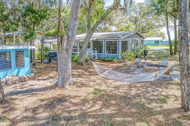 view of yard with a sunroom and a fire pit