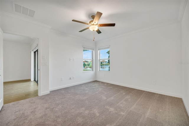 unfurnished room with ceiling fan, carpet floors, and crown molding