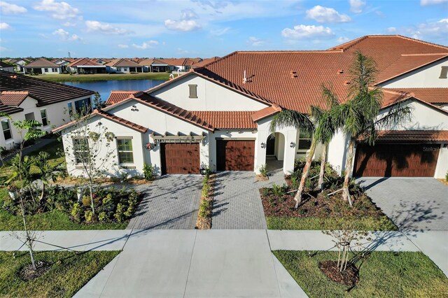 mediterranean / spanish-style house featuring a water view and a garage