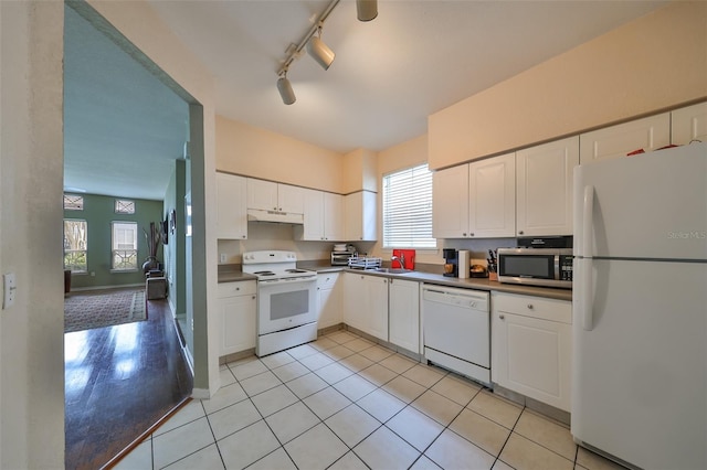 kitchen featuring white cabinets, light tile patterned floors, white appliances, and a wealth of natural light