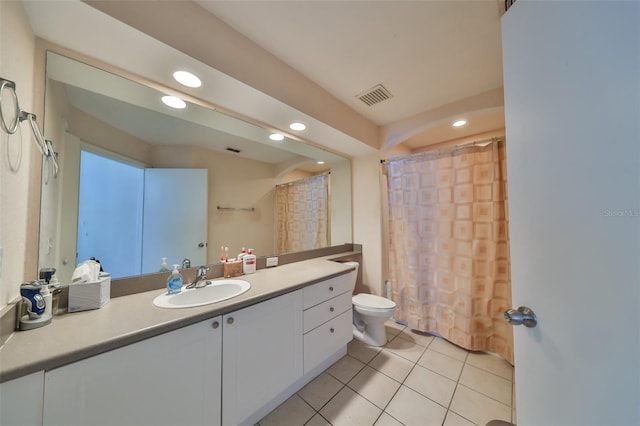 bathroom with toilet, vanity, tile patterned floors, and walk in shower