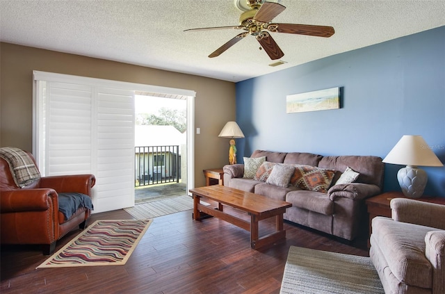 living room featuring a textured ceiling, ceiling fan, and dark wood-type flooring