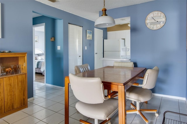 dining room featuring light tile patterned flooring and a textured ceiling