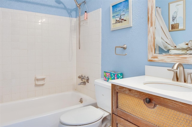 full bathroom featuring vanity, tiled shower / bath combo, and toilet