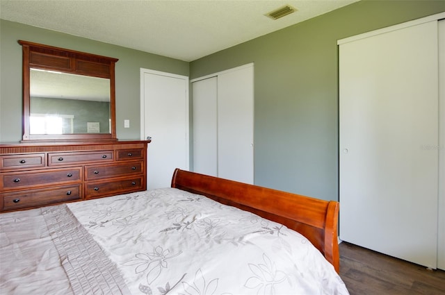 bedroom with a textured ceiling and dark hardwood / wood-style flooring