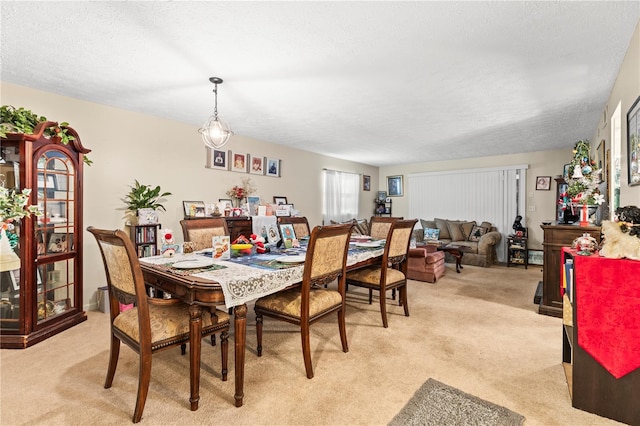 carpeted dining room featuring a textured ceiling