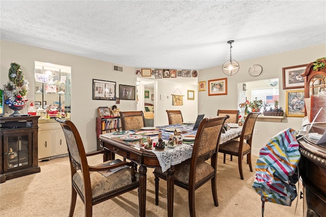 carpeted dining space featuring a textured ceiling