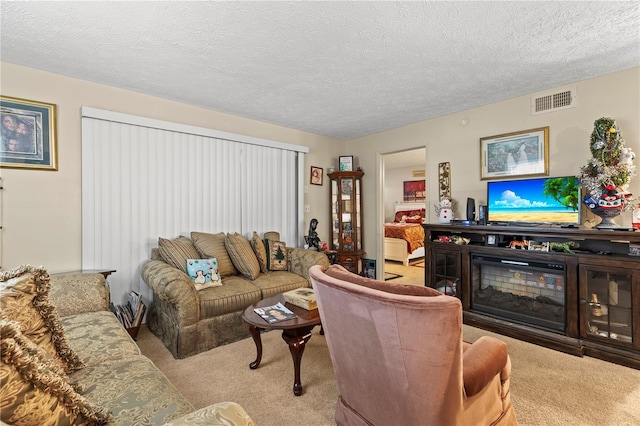 living room with a textured ceiling and light colored carpet