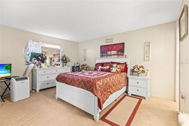 bedroom with a textured ceiling and light carpet