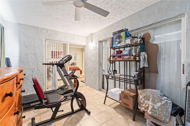 workout room featuring light tile patterned floors, a textured ceiling, and ceiling fan