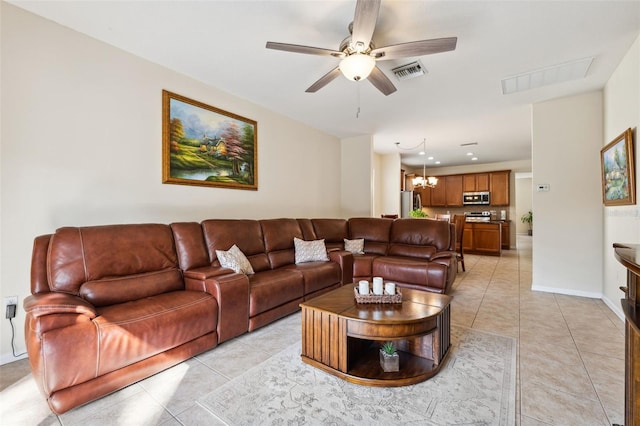 living room with ceiling fan with notable chandelier and light tile patterned floors