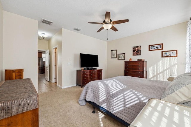 bedroom with stainless steel fridge, ceiling fan, and light colored carpet