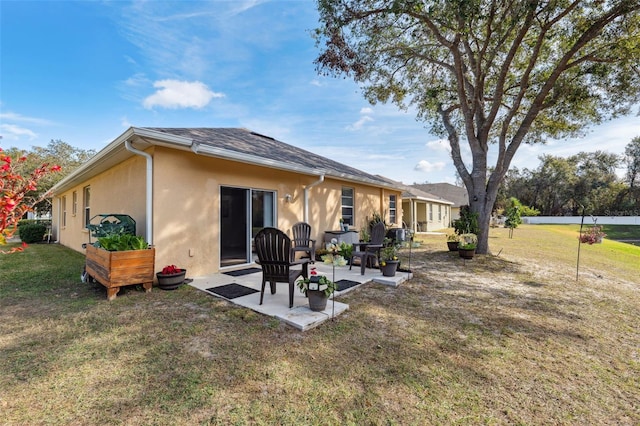 back of house with a lawn and a patio