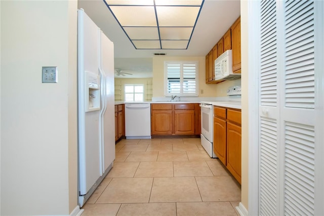 kitchen featuring ceiling fan, white appliances, sink, and light tile patterned floors