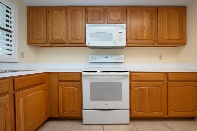 kitchen featuring light tile patterned flooring and white appliances