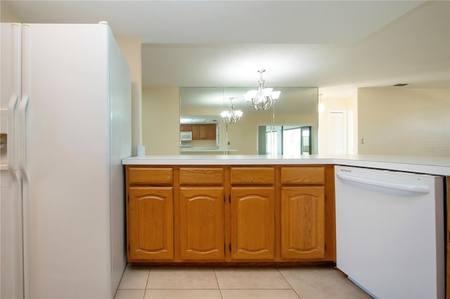 kitchen with kitchen peninsula, white appliances, pendant lighting, a chandelier, and light tile patterned flooring