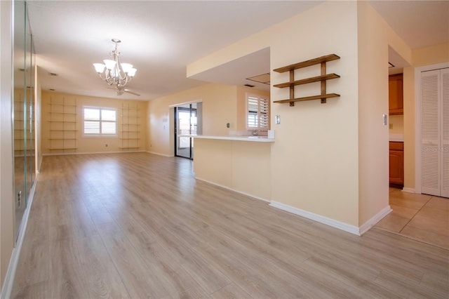 unfurnished living room with light hardwood / wood-style flooring and a notable chandelier