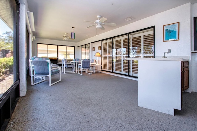 unfurnished sunroom featuring ceiling fan