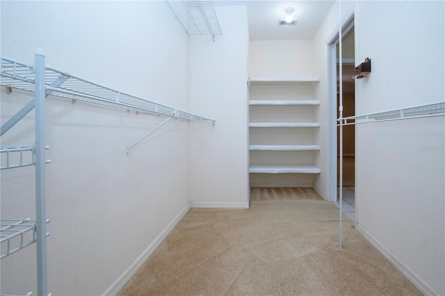 walk in closet featuring light carpet