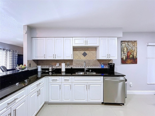 kitchen with dishwasher, backsplash, dark stone counters, sink, and white cabinetry