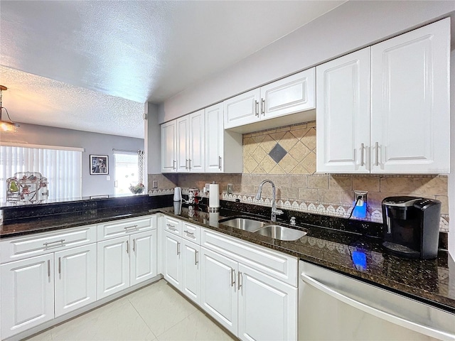 kitchen featuring dark stone countertops, dishwasher, white cabinets, and sink