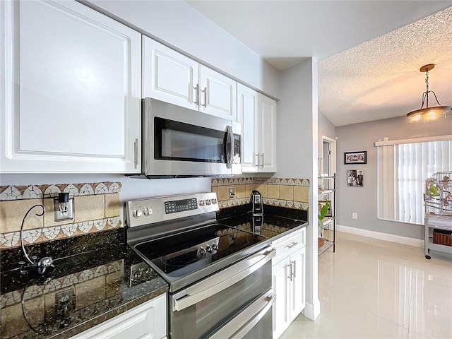 kitchen featuring white cabinets, a textured ceiling, appliances with stainless steel finishes, decorative light fixtures, and light tile patterned flooring