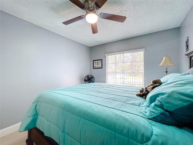 carpeted bedroom featuring a textured ceiling and ceiling fan