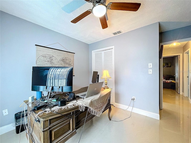 home office with ceiling fan and a textured ceiling