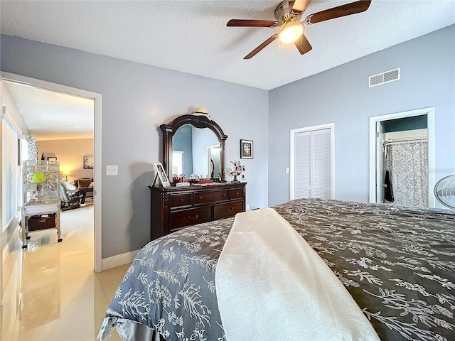 tiled bedroom with a textured ceiling, a closet, and ceiling fan