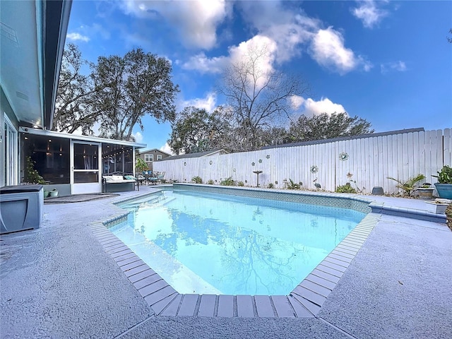 view of swimming pool with a patio area and a sunroom