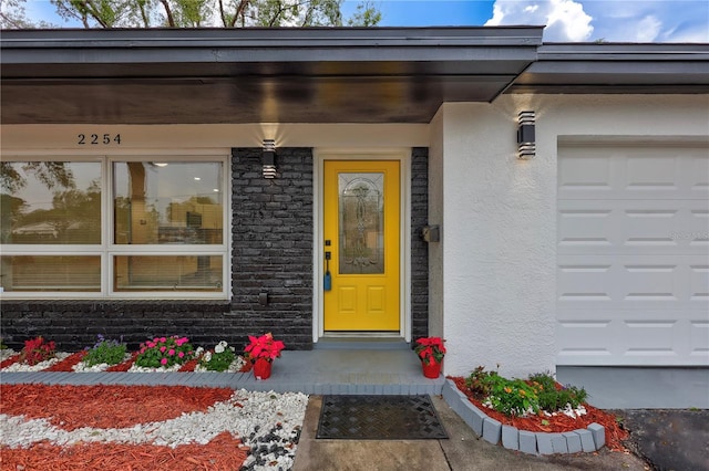 doorway to property with stone siding and stucco siding